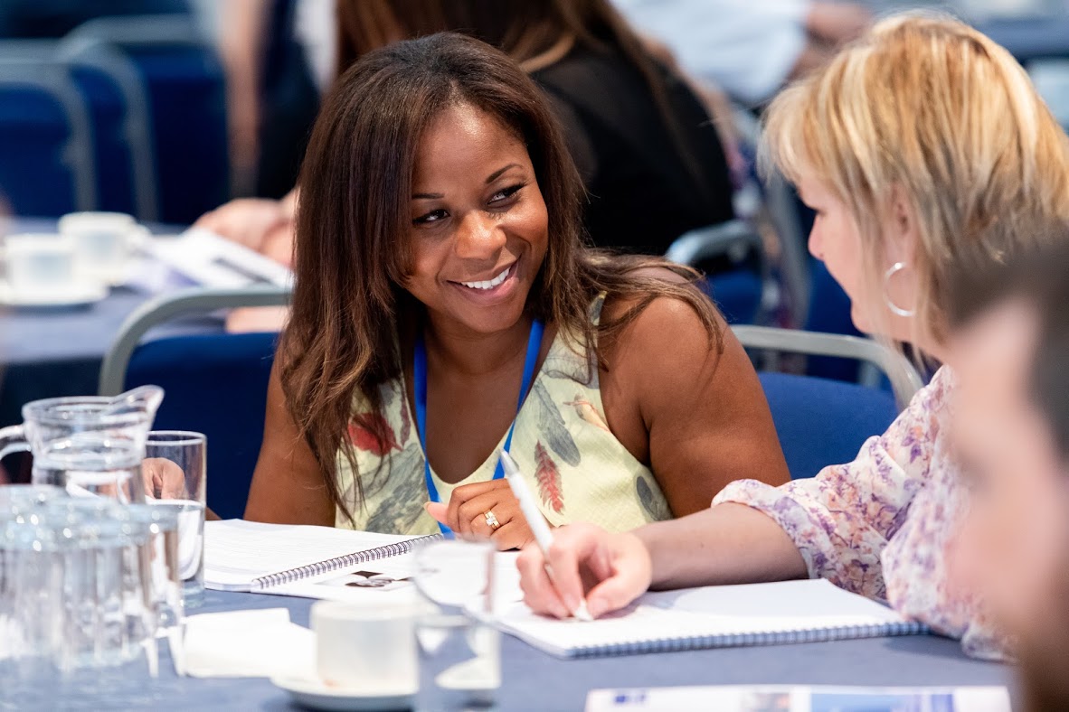 Two Teachers Chatting At A Seminar