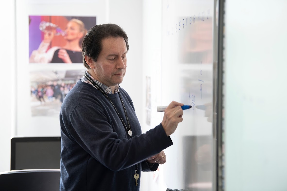 Male Teacher Writing On The Board