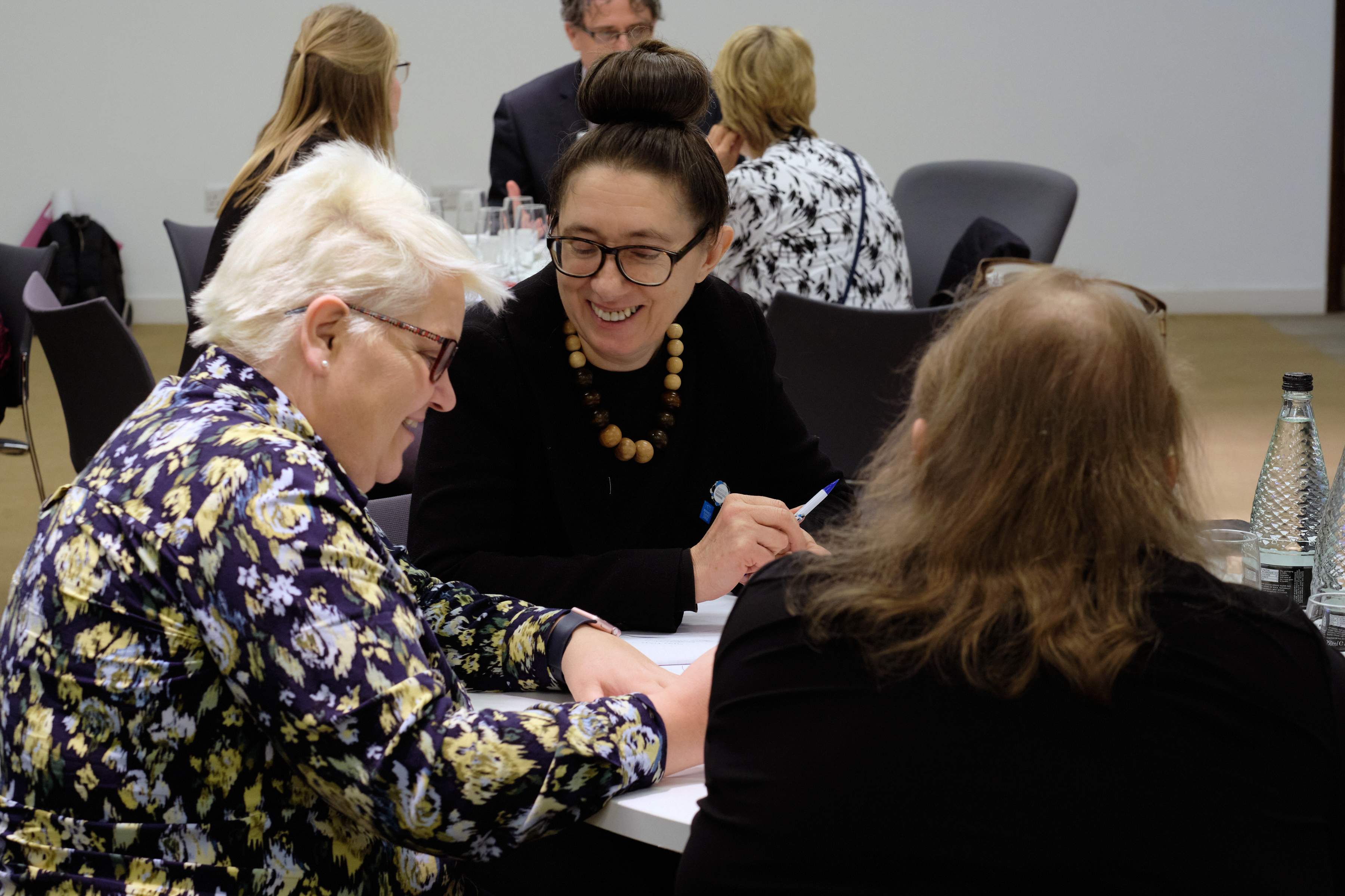 Three Teachers Working Together Sitting Around A Table