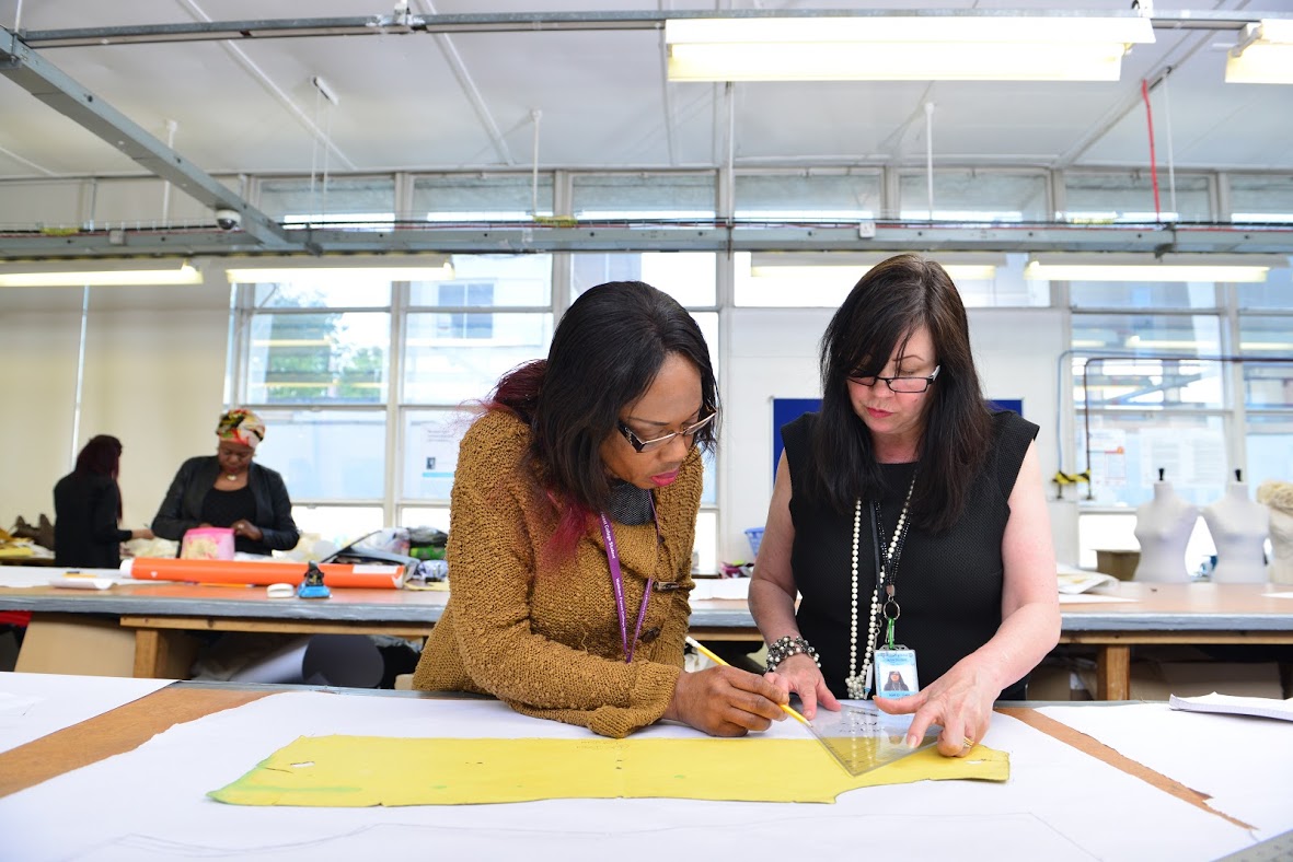 Teacher And Student In An Art Class At A Desk
