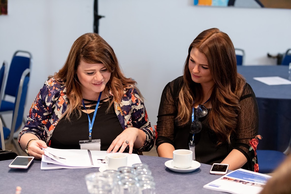 Two Teachers Working Together On An Activity At A Seminar