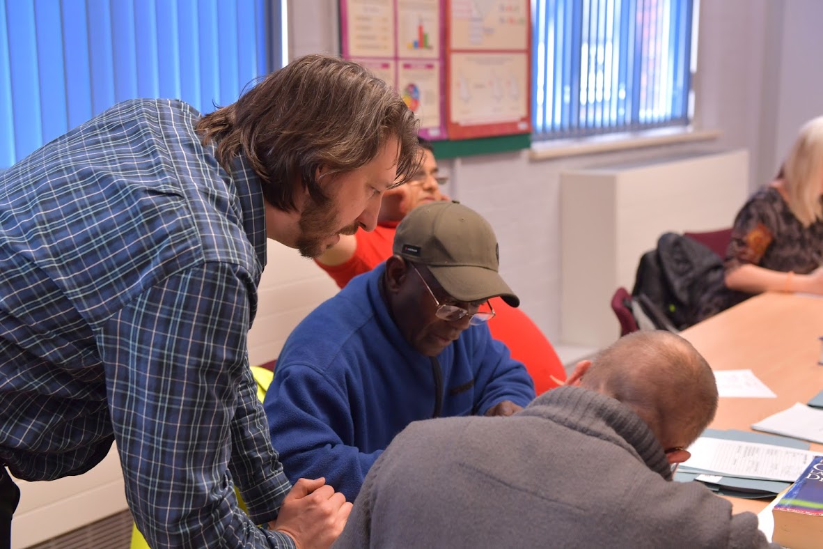 Teacher Helping Some Students In An English Class