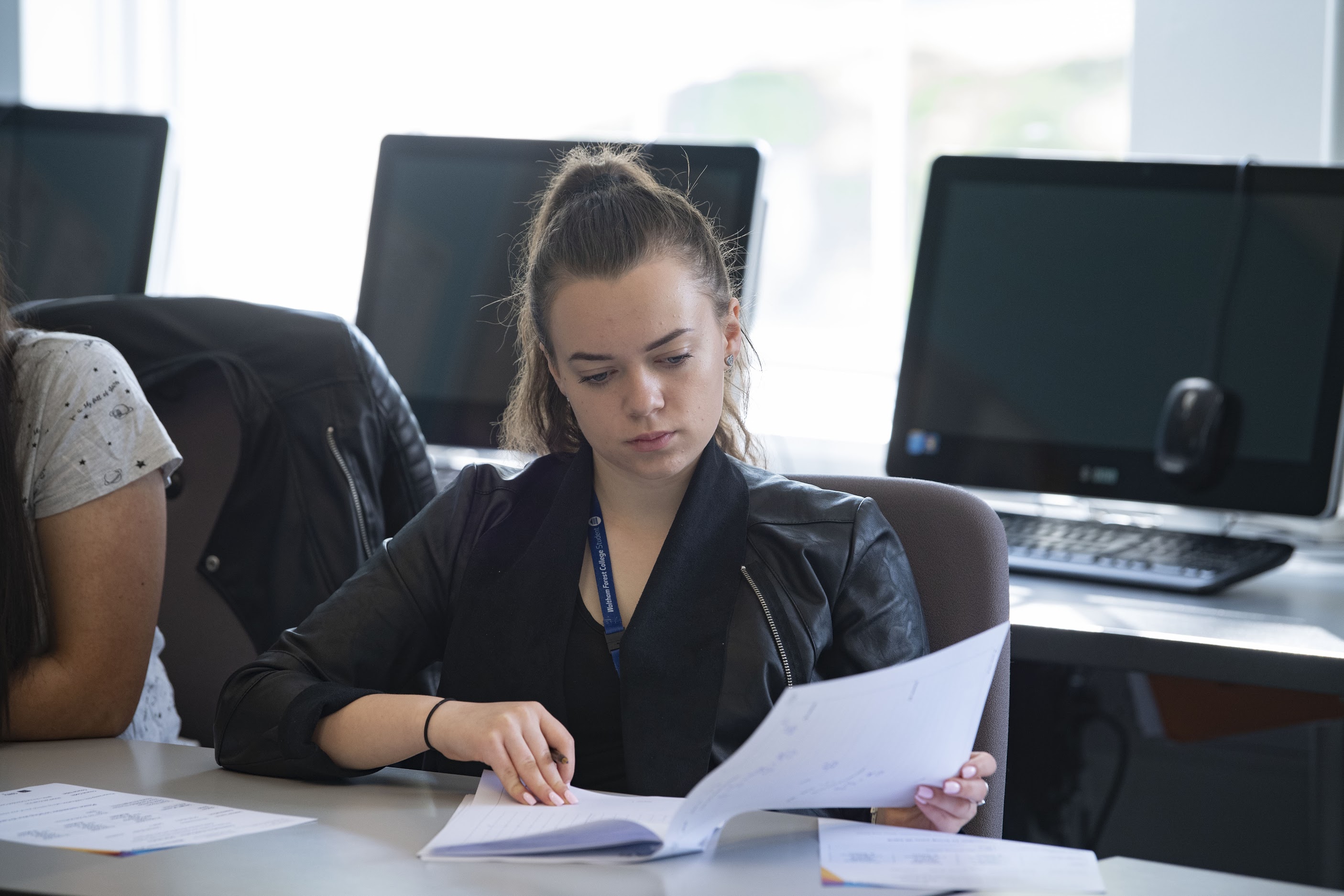 Student reading notes in a classroom