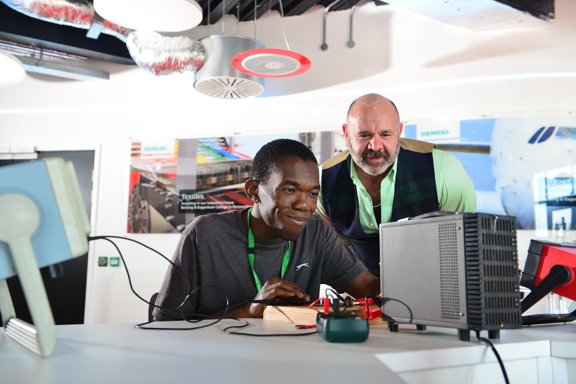 Teacher Helping At Student In An Engineering Class